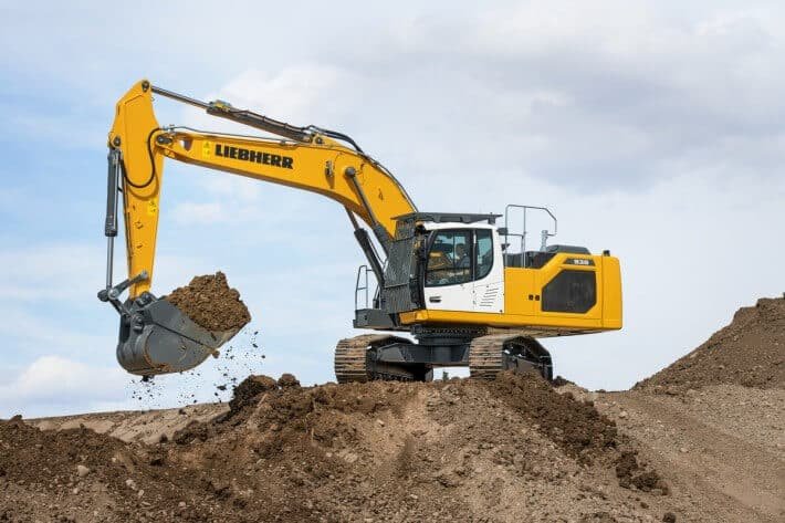 Photograph is showing the crawler excavator working productively with its tracks and long boom.