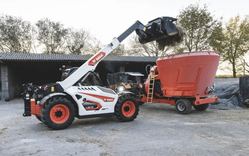 The photograph shows a telescopic loader handling the material.