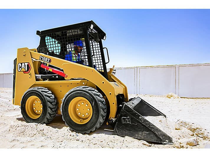 Photograph is showing skid steer loader busy in operation.