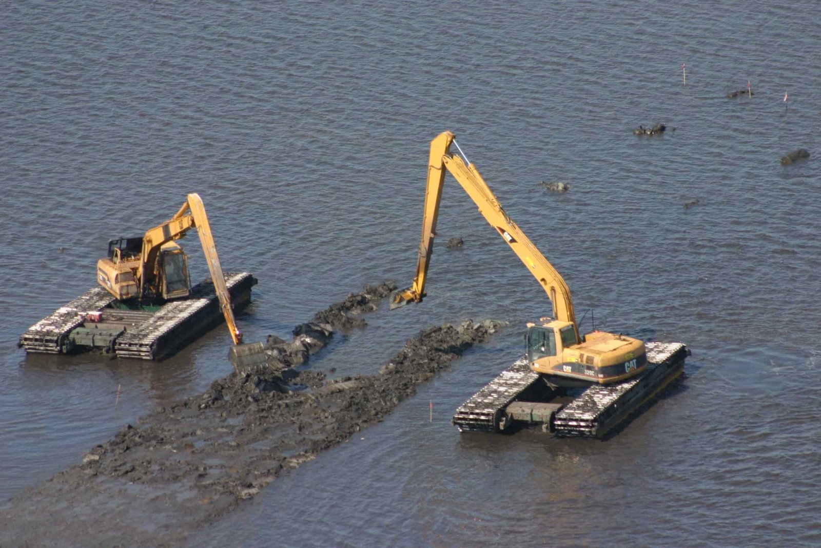 Onsite photograph of crawler excavators during dredging